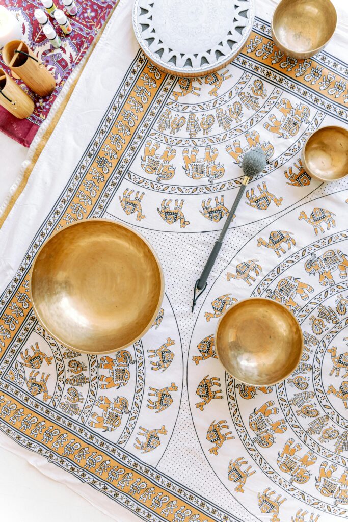 High-angle view of Tibetan singing bowls on a decorative cloth with intricate patterns showcasing spiritual and cultural essence.